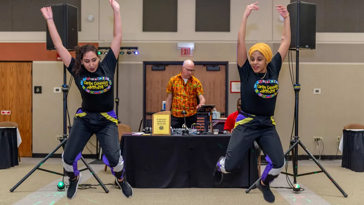 Dancers performing in front of Kris Koch’s DJ booth at a multicultural event